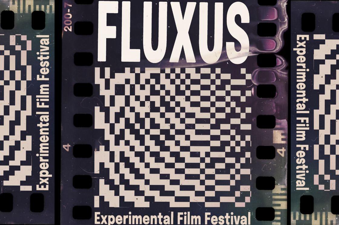 The image is a poster advertising the Fluxus Experimental FIlm Festival. The poster is made with a close scan of a piece of 35mm film. On the piece of film is white text that reads "FLUXUS". Directly below the text is an abstract wave pattern made of white and black pixels.